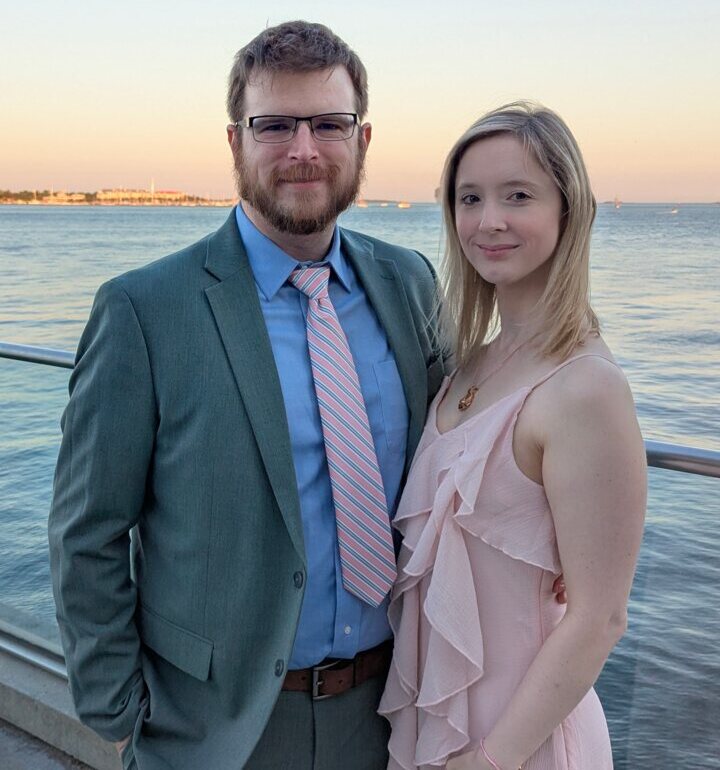 Samuel Price standing with his partner outdoors.